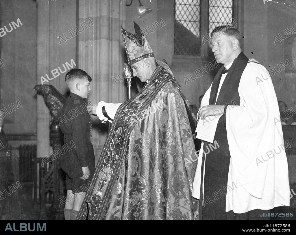 Gallant boy honoured at church service. When the Bishop of Monmouth presented the Gallant Conduct Medal of the Church Lads Brigade to ten year old Robert Harris, of Crindu, Newport during a service at All Saints Church, Newport, Men he said that it was the first time he had witnessed 'such a ceremony' interpolated into a service of the Church'. The boy, a non swimmer was awarded the decoration for his gallantry in saving a three year old girl, who had fallen into the River Ebb at Newport. Picture shows, the Bishop of Monmouth ( the Right Revd Alfred Edwin Morris) pinning the medal on Robert Harris at the unique service at Newport. 11 December 1945. 10 December 1945.