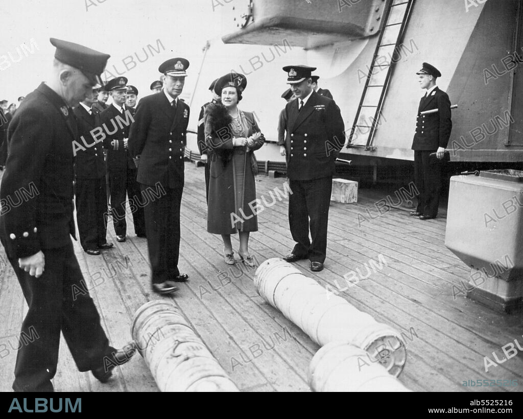 Royal Visit to Famous British Battleship - The King and Queen with the Commanding Officer of the King George V -  Captain T. E. Halsey, D.S.O., R.N., watching 14-inch cordite charges being rolled across the deck. Picture taken at a Northern Base when the King and Queen accompanied by Princess Elizabeth and Princess Margaret, paid a farewell visit to he British Battle-ship King George V before she left to join Britain's East Indies Fleet. It is now revealed that the King George V took part in tie great air-sea operations against Japanese oil supplies in Sumatra. April 16, 1945. (Photo by PNA).