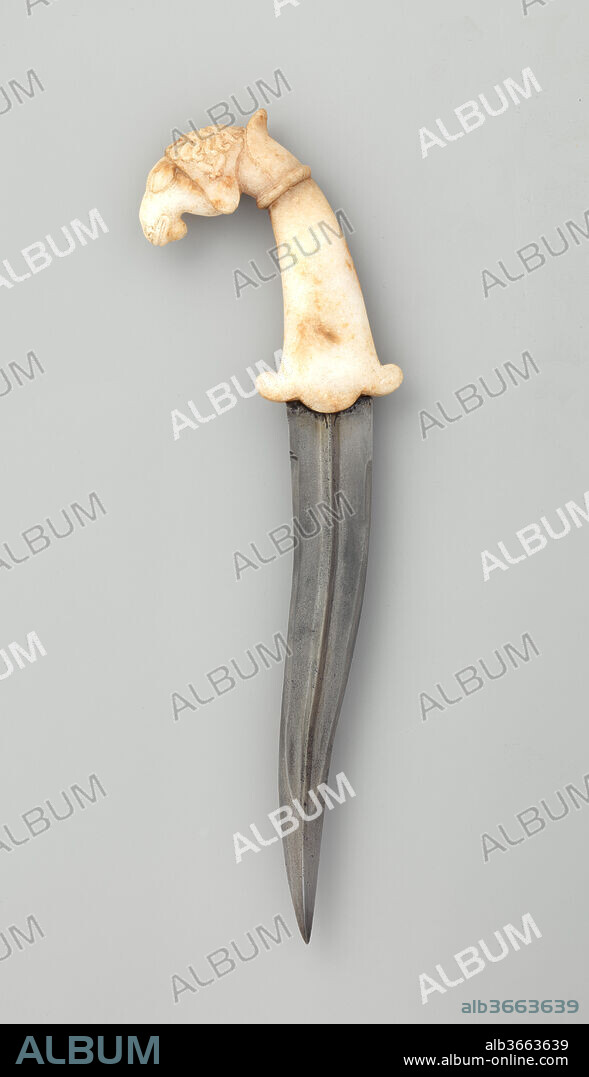 Dagger (Khanjar). Culture: Indian. Dimensions: L. 13 3/8 in. (34 cm); L. of blade 8 1/16 in. (22 cm). Date: 17th-18th century.
The sheep's head pommel of this dagger is extremely distinctive and rare. The great majority of Indian and Persian <i>khanjar</i> daggers have smooth hilts and rounded pommels. While there are also many examples with zoomorphic pommels, the majority take the form of a horse's head, or, occasionally, a lion's head. In addition, the animal elements of most zoomorphic <i>khanjar</i> hilts are rendered in a very refined, delicate, and stylized manner. In contrast to this, the carving of the sheep's head on this dagger is done in a very lively, naturalistic, and animated style, giving the hilt an immediate visual appeal as a piece of sculpture. The hilt is marble, which is also unusual, most <i>khanjar</i> daggers having jade hilts. The blade is gently recurved, with a raised medial ridge and a thickened tip that is a flattened lozenge in cross-section.