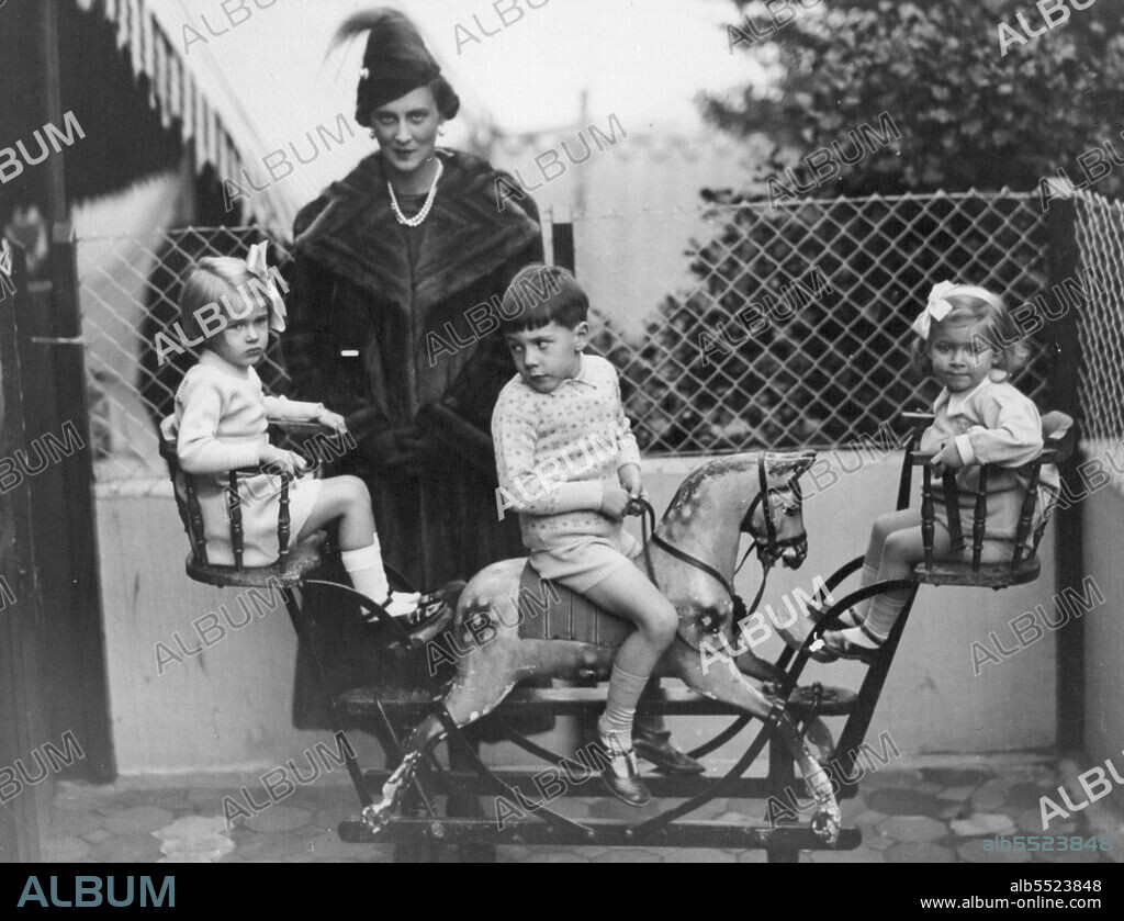 H.R.H. The Duchess of Kent Opens The Children's Rest At Cambridge Park, Twickenham -- The Duchess of Kent with some of the kiddies on a rocking-horse. October 26, 1937. (Photo by Sport & General Press Agency, Limited).