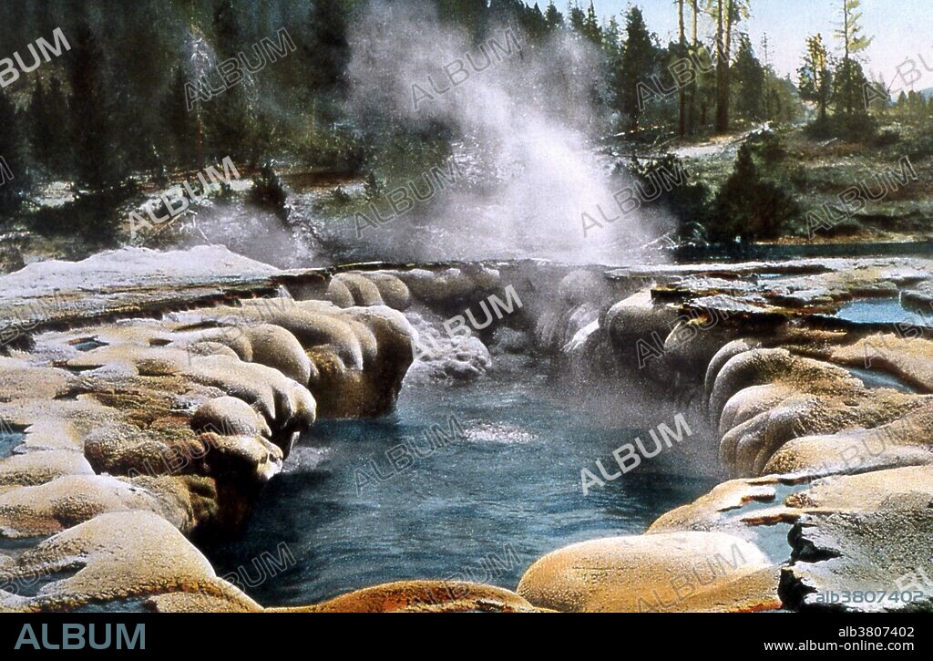 Oblong Geyser was named for the shape of its large oblong shaped pool. While technically a fountain-type geyser, Oblongs eruptions can't really be classified as bursting type eruptions. The eruptions are more like a very large and heavy boiling that covers the pool and raises the water in surges of 25 feet or more. Oblong is a major geyser. It is not too tall, usually the maximum height is around 25 feet but in exceptional eruptions it has reached 50 feet. What makes it a major geyser is the amount of water it puts out during its 5 minute eruption. Because the water flows almost directly into the Firehole river, it is not possible to measure the amount of water expelled during an eruption but it is estimated at over 10,000 gallons. That is a little more water than is expelled during a large eruption of Old Faithful. Yellowstone National Park is a national park located primarily in the state of Wyoming, although it also extends into Montana and Idaho. Photographed by Frank J. Haynes, no date.