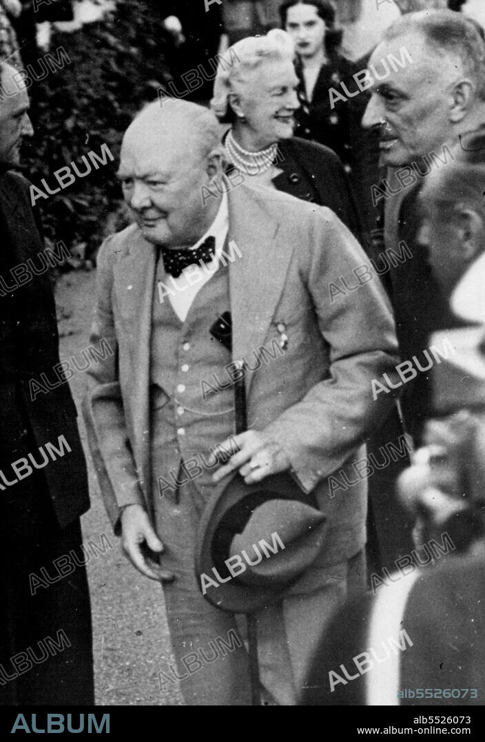 The Prime Minister On Holiday: Mr. Winston Churchill followed by Mrs. Churchill, arriving fro the ceremony.Mr. Winston Churchill who with Mrs. Churchill is spending a short holiday on the Riviera, was among the many interested visitors to watch the famous ceremony of "Beating Retreat" carried out by the Royal Marine Bands of the Mediterranean fleet at Nice. September 18, 1952. (Photo by Sport & General Press Agency, Limited).