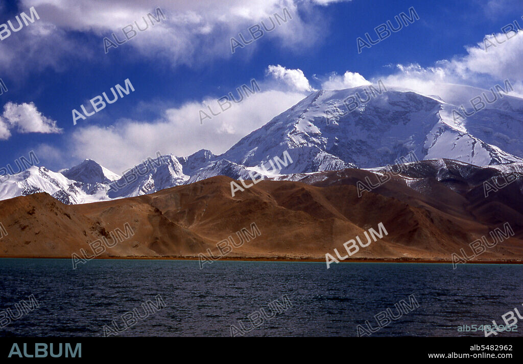 Muztagh Ata, or Muztagata (Uyghur: 'ice-mountain-father'), is the second highest (7546 metres) of the mountains which form the northern edge of the Tibetan Plateau (not the second highest of the mountains of the Tibetan Plateau). It is sometimes regarded as being part of the Kunlun Shan, although physically it is more closely connected to the Pamirs. It is also reputedly one of the easiest 7,000 m peaks in the world to climb, due to its gentle western slope and the comparatively drier weather of Xinjiang. The Zhongba Gonglu or Karakoram Highway is an engineering marvel that was opened in 1986 and remains the highest paved road in the world. It connects China and Pakistan across the Karakoram mountain range, through the Khunjerab Pass, at an altitude of 4,693 m/15,397 ft.