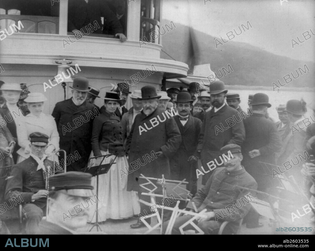 President Benjamin Harrison with James G. Blaine, Secretary of State, Henry Cabot Lodge, and group of other people posed, possibly on the forward deck of the Frenchman's Bay steamer Sappho, with several men of the Bar Harbor Band, Maine, 1892.