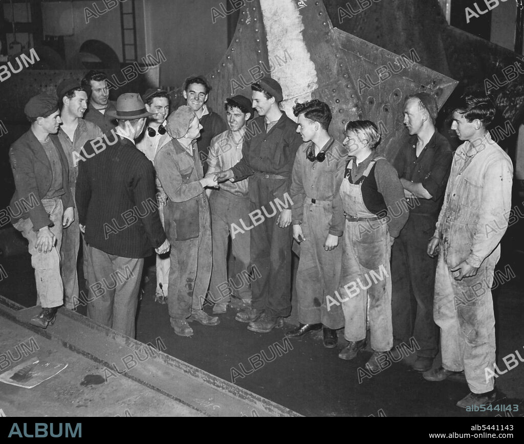 Edward James Goulding, foreman of the fabricating shop, where Arthur will be working, introduces him to his fellow workers, Shaking hands, with new recruit is 18 year old Albert McNair, a 3rd year boiler maker's apprentice. He meets his working cobbers - Teamwork is important in the fabricating shop where Arthur will be working, so foreman Edward James Goulding introduces fellow workers. Shaking hands with him is Albert McNair. August 13, 1949.