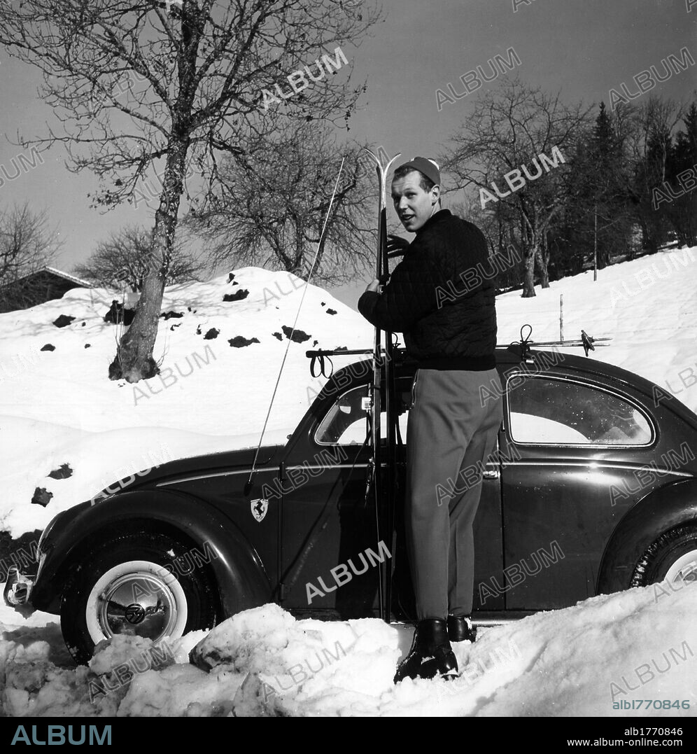 Victor Emmanuel of Savoy on the ski slopes. Victor Emmanuel of Savoy holding his skis in his hand next to his Volkswagen. Gstaad,  December 1959.