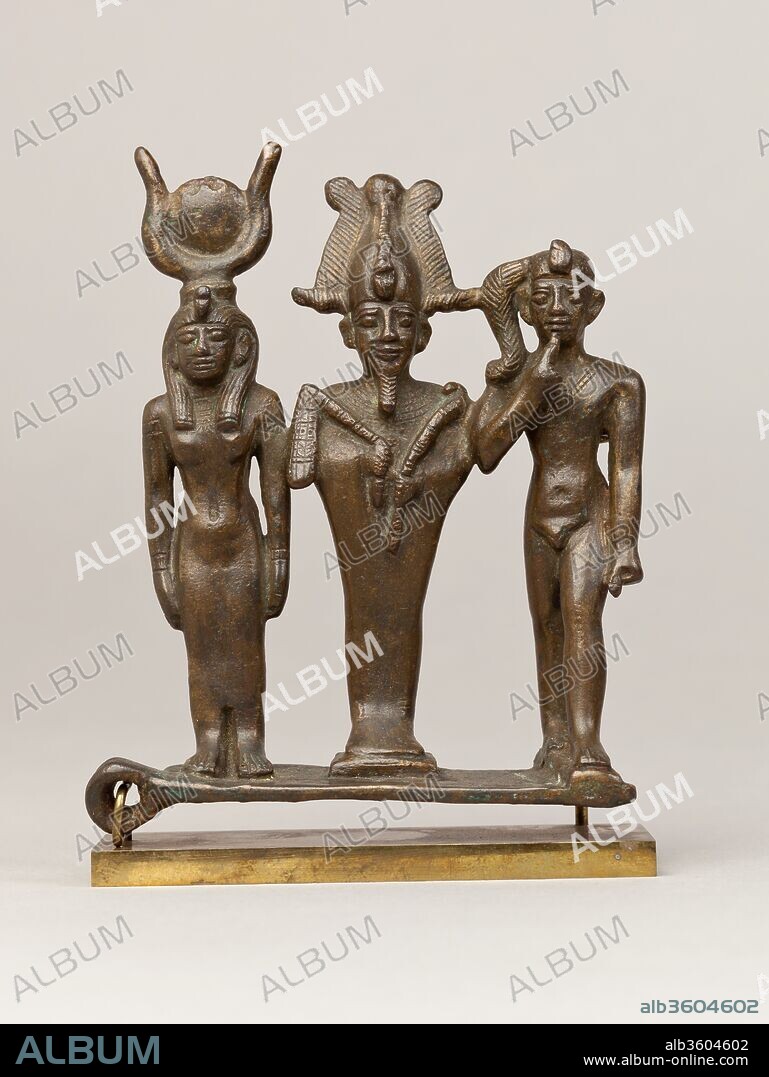 Triad of Osiris, Isis, and Horus. Dimensions: H. 12.4 cm (4 7/8 in.); W. 10.2 cm (4 in.); D. 4.8 cm (1 7/8 in.). Date: 664-30 B.C..
The immensely popular gods Osiris, Isis and Harpokrates are here represented as a triad standing in a row on a single base. Several loops study the group - one projecting from the side of the base at right angles, and others behind Harpokrates and Osiris: whether they are intended to allow for fixation in multiple contexts, or a rather a more symbolic addition, is a question.
