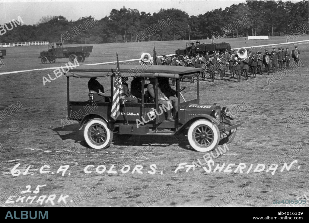 61st Cavalry Artillery colours, Fort Sheridan, Illinois, USA, 1925. A truck with a band marching in the background. Fort Sheridan was a US Army base on the shores of Lake Michigan just north of Chicago.