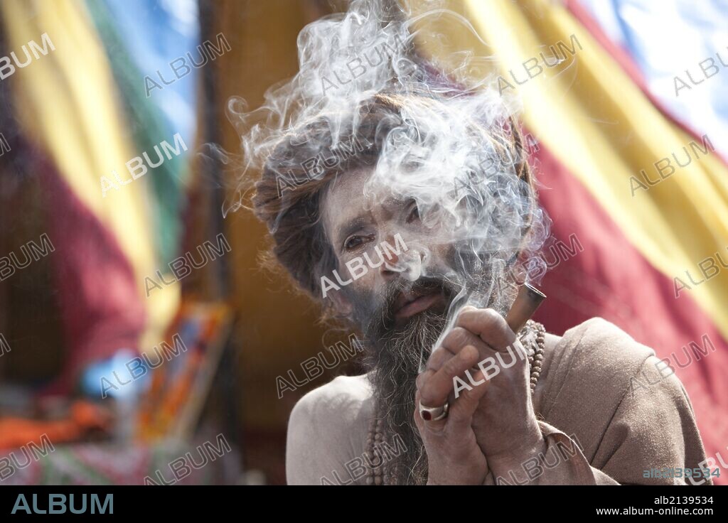 Sadhu, Naga Baba (naked Baba, belonging to the Junna brotherhood) smoking a chilum at the Kumbh Mela in Haridwar, February 2010.