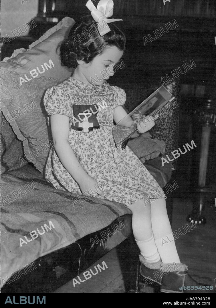 Tania Szabo at Home After Receiving Heroic Mogther's George Cross From The King At Buckingham Palace -- Tania Szabo - wearing the George Cross awarded her mother, and which she received from the King - looking at the picture at her mother on her return to her home in Brixton, London.Four-years-old Tania Szabo went to Buckingham Palace, London, to receive the George Cross from the hands of the King, which was awarded to her heroic mother Madame Violette Szabo "for a magnificent example of courage and steadfastness" as a British agent in France. She was shot in 1944 by the Germans after torture had failed to make her talk. She was then 24. She has been parachuted into France during the war to do espionage work. January 28, 1947.