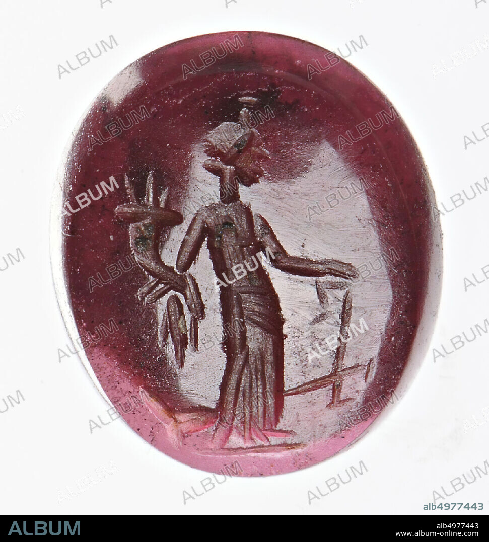 Vz: the winged goddess wears a chiton, himation and a helmet, she has a rudder and two ears of corn in her left hand and a cornucopia in her right hand., Gem, intaglio, ringstone, garnet, Color: light purple, Form : oval, Machined: front convex, back concave, Method: body modeling with thick rounded disc grooves, detailing with thin sharp wheel grooves., 10 x 8.5 mm, D. 2 mm, 1st - 2nd century AD. 1-200 AD.
