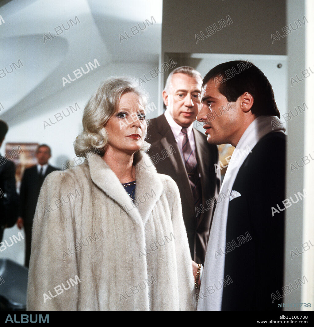 DERRICK / Dead Goldfish / Julia Stettner (ELISABETH WIEDEMANN) is irritated by what Chief Inspector Derrick (HORST TAPPERT) tells her about her acquaintance Roland Marks (HANS GEORG PANCZAK) from an ad. / Headline: DERRICK / BRD 1985.