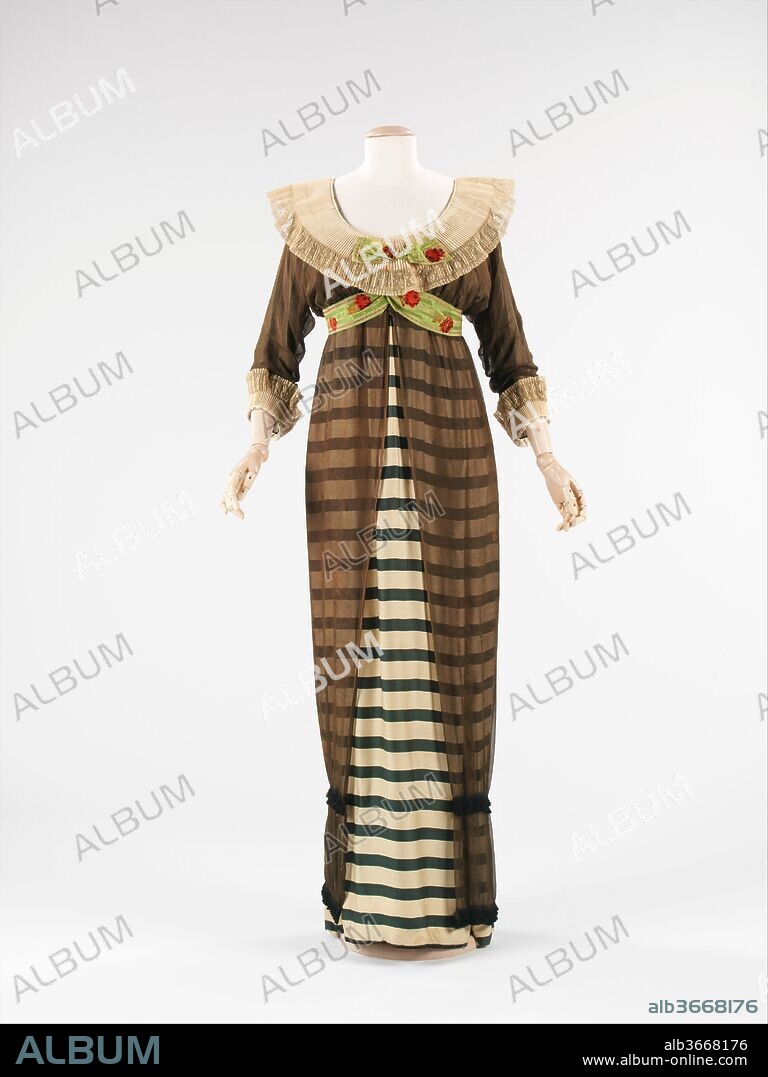 Evening dress. Culture: French. Designer: Paul Poiret (French, Paris 1879-1944 Paris). Date: 1910.
<p>A rare example of Paul Poiret's early revolutionary designs loosely based on the upright, columnar, high-waisted styles worn in ancient Greece, this gown is an innovative melding of the avant-garde and the traditional. The tubular shape and graphic horizontal stripes are harbingers of the modern era, while the below-the-knee gathering of the overskirt suggests the "hobble skirt" that Poiret introduced in 1910 and was briefly the height of fashion. Decorative touches taken from traditional sources mollify the radical form. One of Poiret's signature decorative techniques was to use folkloric textiles and trims that he collected on his travels. Here the collar and cuffs are fashioned from a traditional French pleated linen bonnet, and brightly colored brocade ribbons that would have adorned a festive folk bonnet or costume encircle the raised waistline.</p>
<p>Requiring less restrictive undergarments and conforming more to the natural shape of the body, Poiret's designs of 1908-11 are regarded as pivotal in the transition from the rigidly corseted silhouettes of the Victorian and Edwardian eras to styles providing greater freedom and comfort in dress that would characterize twentieth-century fashion.</p>.