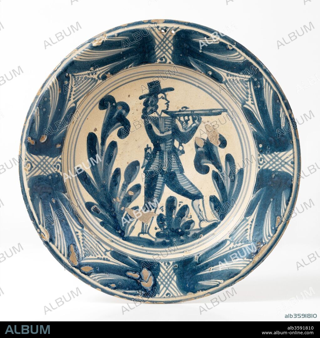 Plato, Mediados del siglo XVIII, Cerámica (loza decorada en azul, con figura de cazador con calzón corto, levita, sombrero de ala, y escopeta; y cenefa con el motivo de la corbata), de Barcelona, Diámetro: 36 cm.