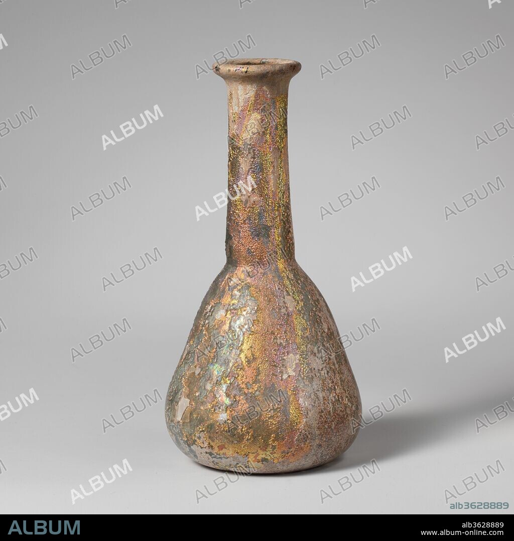 Glass perfume bottle. Culture: Roman. Dimensions: 5 3/4in. (14.6cm)
Other: 2 13/16 in. (7.1 cm)
Diam. of rim: 1 1/4 in. (3.2 cm). Date: 2nd-3rd century A.D..
Translucent pale green.
Uneven rim folded out, round, and in, with thick rounded outer lip; cylindrical neck, expanding downward, tooled in around base; conical body, curving in to flat bottom.
Intact; many bubbles; deep pitting and brilliant iridescence with areas of creamy brown weathering.
