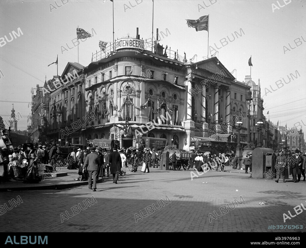 The London Pavilion theatre, Piccadilly Circus, London, 1902. It is decorated in readiness for the coronation of Edward VII in June 1902. The street outside is bustling with life. The coronation was delayed until 9 August due to the health of the King.