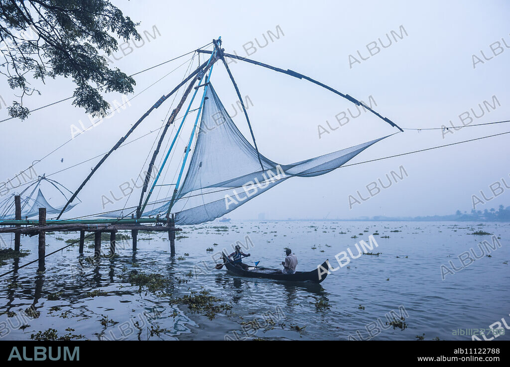 Fishermen at the traditional Chinese fishing nets, Fort Kochi (Cochin), Kerala, India, Asia.