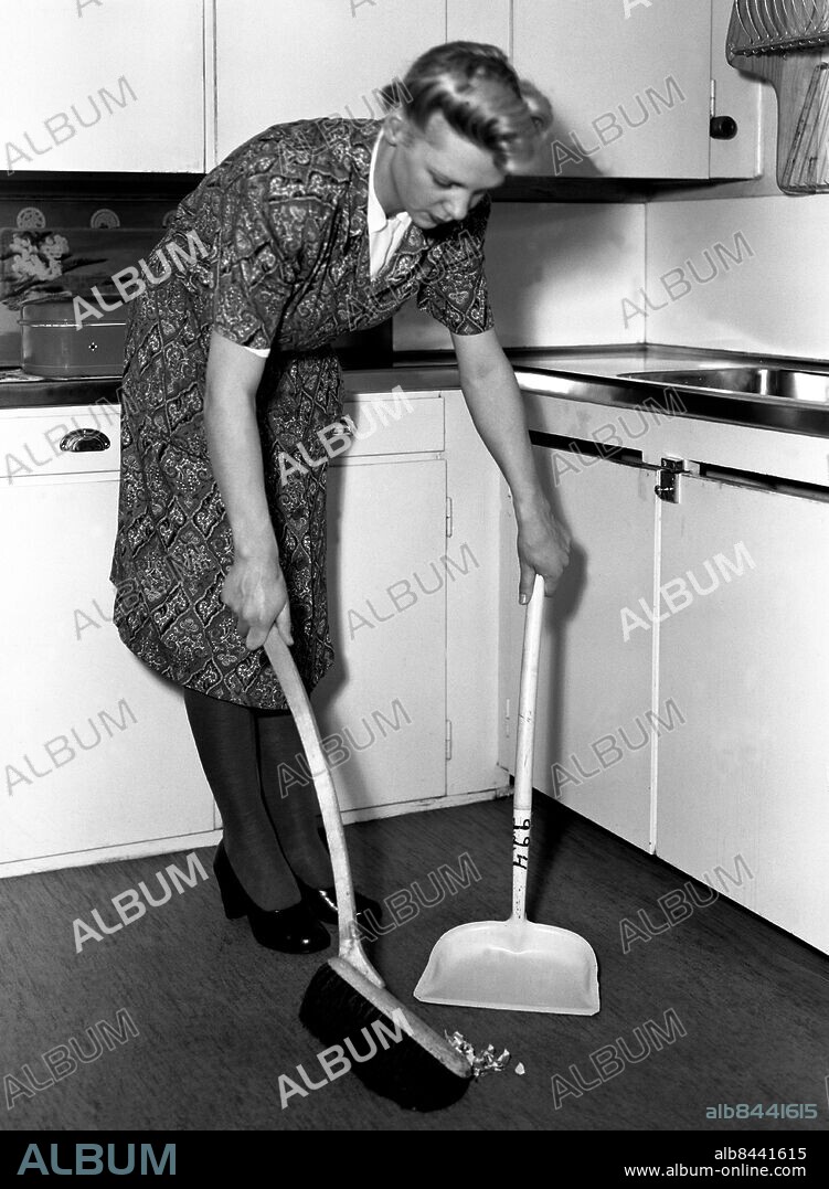 ARKIV 1947. Kvinna sopar upp på golvet i ett modernt 40-talskök.. Woman sweep the floor in a modern kitchen 1947.. Foto: TT Historical/1900. Scanpix Sweden.