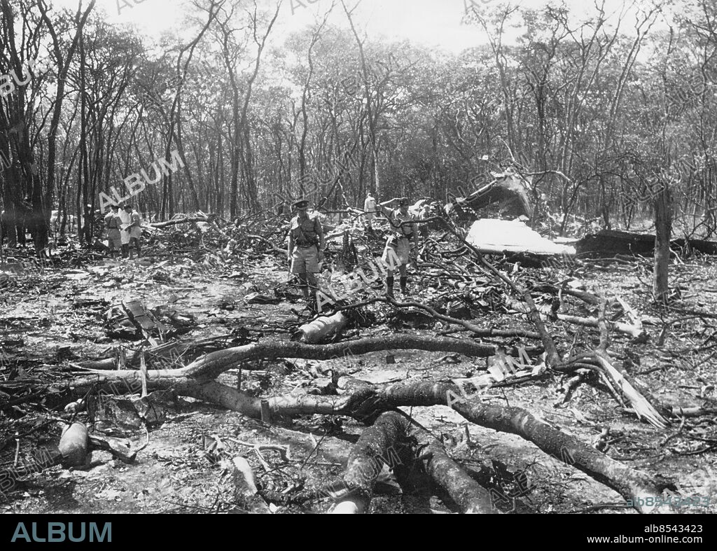 Orig. bildtext... MR. HAMMARSKJÖLD DIES IN AIR CRASH. Mr. Dag Hammarskjoeld, United Nations Secretary-General died in a plane crash near Ndola in Northern Rhodesia on Monday. The 56-year-old Secretary-General was to have met President Tshomhe of Katanga at Ndola for peace talks which, it was hoped, would bring abouta cease-fire. Thirteen of the fourteen passengers and crew died when the aircraft crashed after a series of mid-air explosions. The sole survivor was a United Nations security guard. Photo shows: (Original just received in London) Officers inspecting the strewn wreckage. Trees had been felled by the aircraft as it crashed. Anm. D. Hammarskjöld, 1905-1961, ämbetsman, FN:s generalsekreterare från 1953. Omkom vid en flygolycka i Ndola i Nordrhodesia, nuvarande Zambia. Kongokrisen persons: DAG HAMMARSKJÖLD* sites: AFRIKA;NDOLA;SVERIGE*.