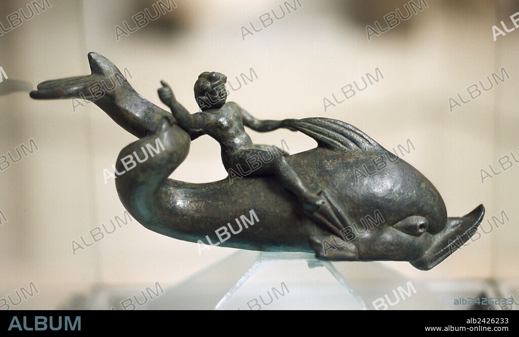EROS. Dios del Amor entre los griegos. ESTATUILLA DE EROS MONTADO EN UN DELFIN. Realizada en bronce (siglo II d. C.). Museo de Efeso. Selçuk. Turquía.