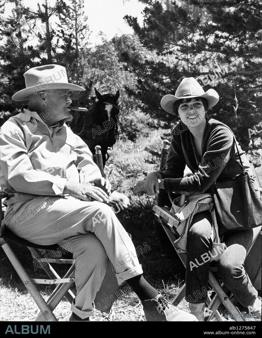 HENRY HATHAWAY und JANET MARGOLIN in NEVADA SMITH, 1966, unter der Regie von HENRY HATHAWAY. Copyright JOSEPH E. LEVINE/PARAMOUNT. Getting into the spirit of "Nevada Smith", producer-director Henry Hathaway admires young New Yorker Janet Margolin in her new Western hat. In the Paramount adventure drama adaptation of Harold Robbins "The Carpetbaggers".