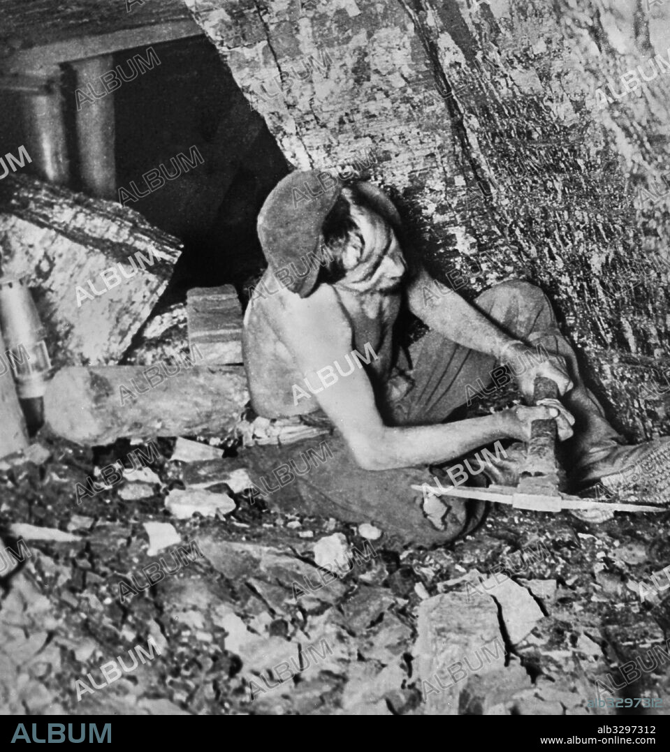 Miner Working With His Pick on the Coal Face. c1920.