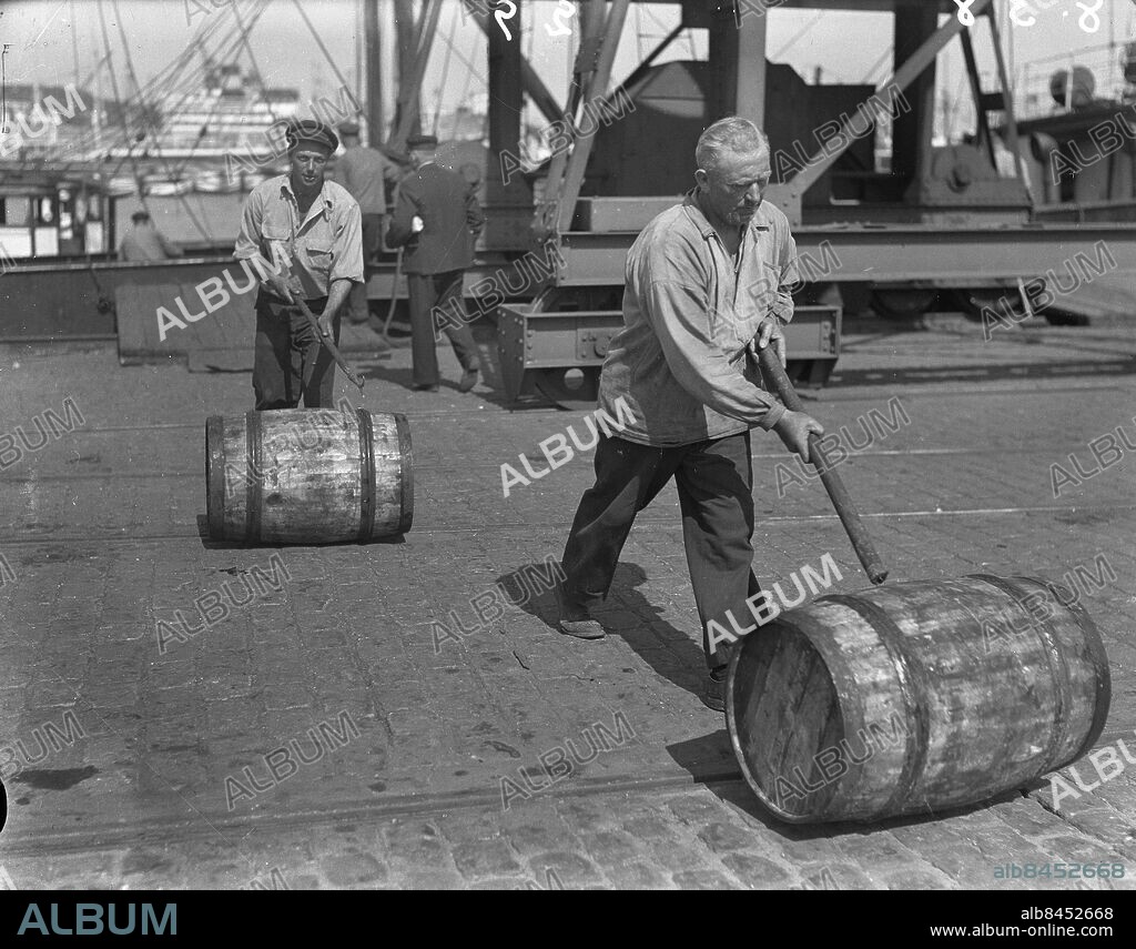 Göteborg 1938-08-06 - Stuveriarbetare rullar trätunnor i hamnen *** Local Caption *** GT Låda 1938-augusti-01. KAMERAREPORTAGE.