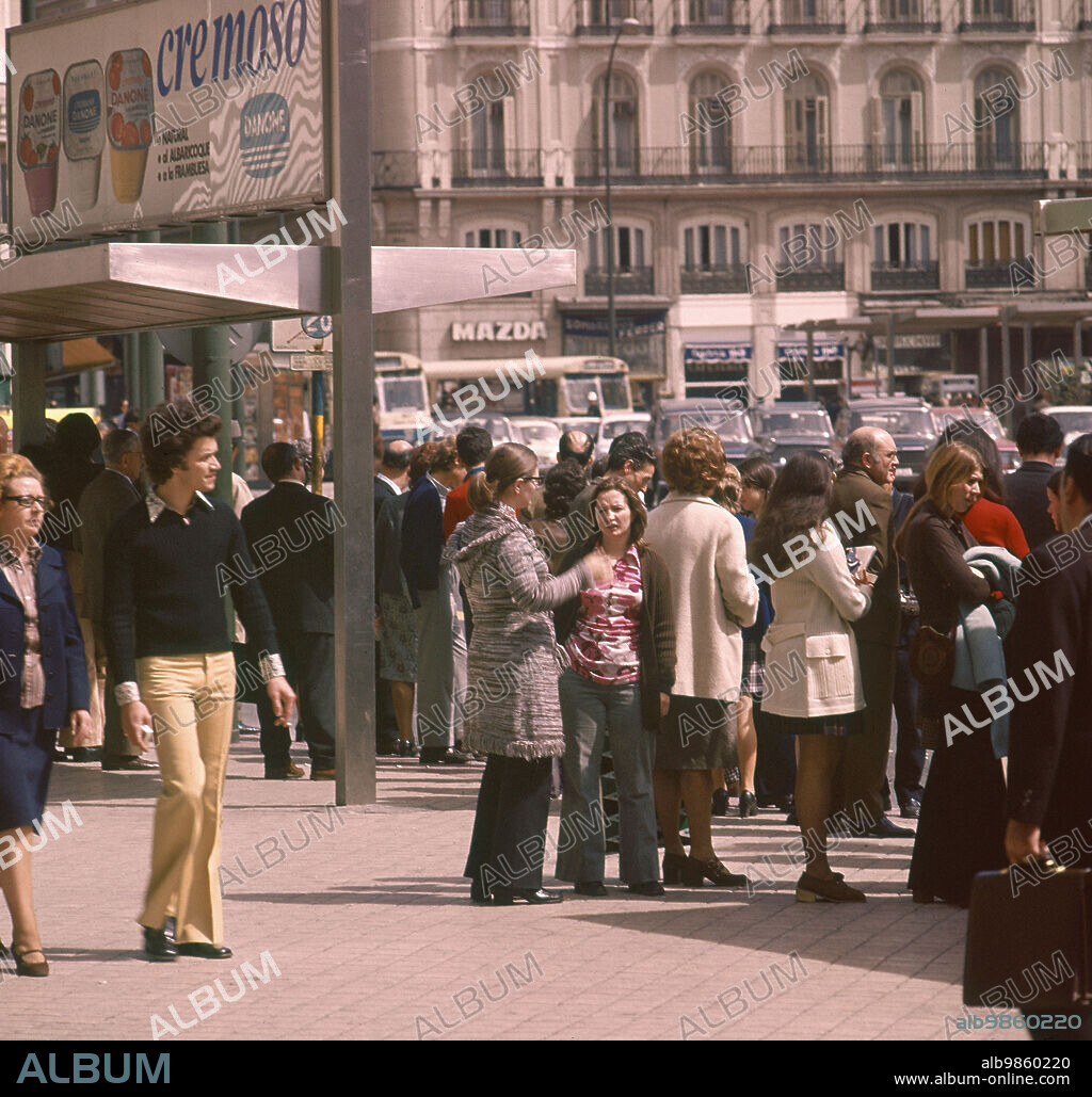 GRUPO DE PERSONAS ESPERANDO AL AUTOBUS EN LA PUERTA DEL SOL.
