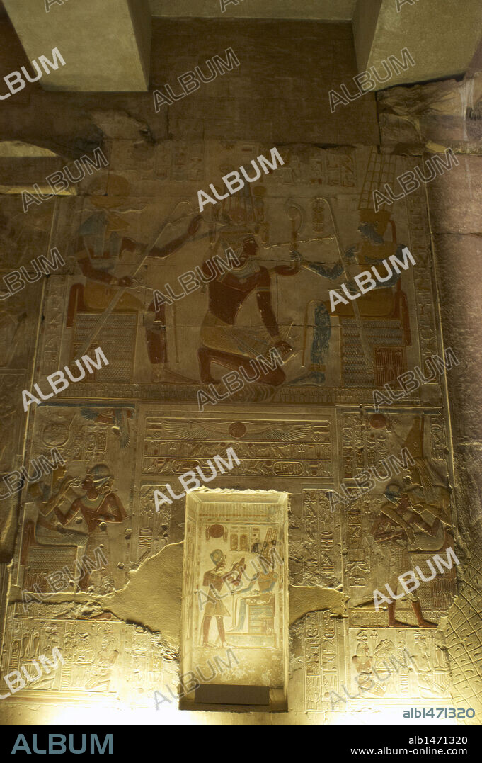 ARTE EGIPCIO. EGIPTO. TEMPLO DE SETI I en ABIDOS (ABYDOS). Mandado construir por el faraón de la Dinastía XIX del Imperio Nuevo, y terminado por su hijo Ramses II. Relieves con restos de policromía original de la segunda sala hipóstila. "SETI I arrodillado, recibiendo emblemas del dios Amón. A la izquierda, el dios Khunum o Jnum, con cabeza de carnero" En la parte inferior representación de faraón con otras divinidades. Abidos. Egipto. Norte de Africa.