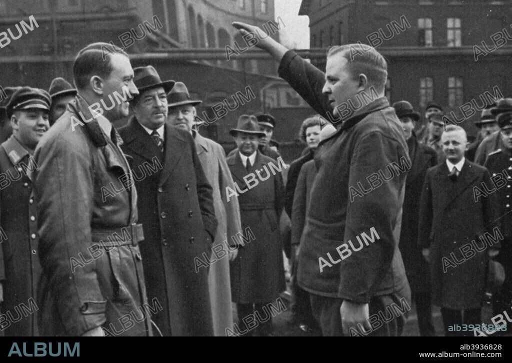 Adolf Hitler saluted by a representative of the staff of a factory, Germany, 1936. Hitler (1889-1945) visiting a factory. A print from Adolf Hitler. Bilder aus dem Leben des Führers, Hamburg: Cigaretten/Bilderdienst Hamburg/Bahrenfeld, 1936.