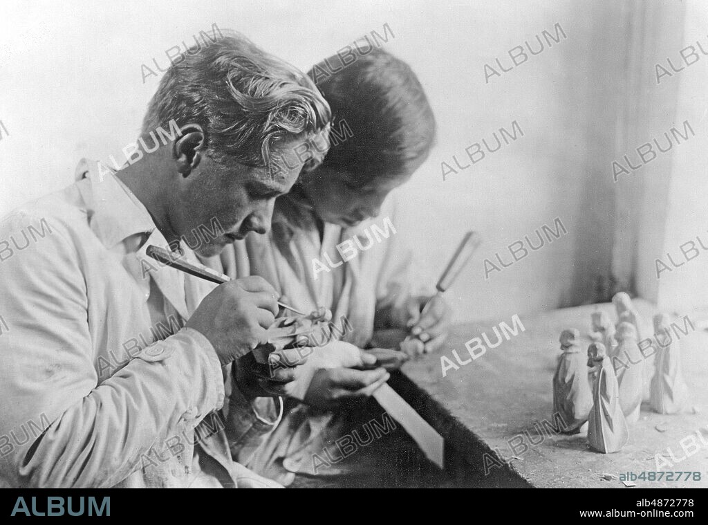 GERMANY OBERAMMERGAU around 1930. Orig, caption ... FROM THE WORKSHOPS OF THE OBERAMMERGAUER-HERRGOTTS-SCHNITZER. Carving apprentices at work in the workshops Gg. Lang sel. Erben, Oberammergau Photo: Atlantic Photo-Gesellschaft / AB Text & Bilder / SVT / Code: 5600 Folder: German wood sculpture 5875 A5 Georg Lang selig Erben Bildserier Photo report Sculptures Sculptors Chisels Apprentices sites: GERMANY; OBERAMMERGAU PhotoDate: 193? - ?? -? ?.