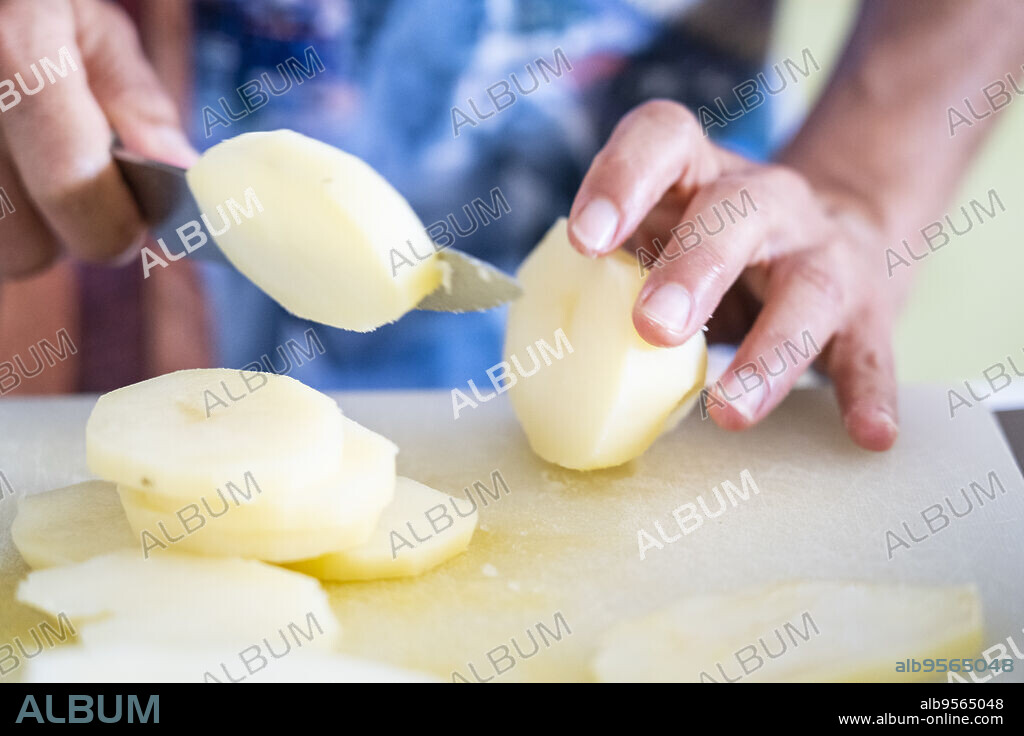 cutting potatoes to cook moussaka, mallorca, spain.
