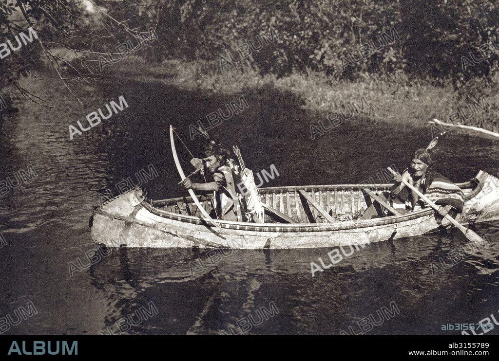 MInnesota:  c. 1900. A Photogravure titled: Ojibwa, The Hunters, with two Ojibwas hunting from a birchbark canoe.