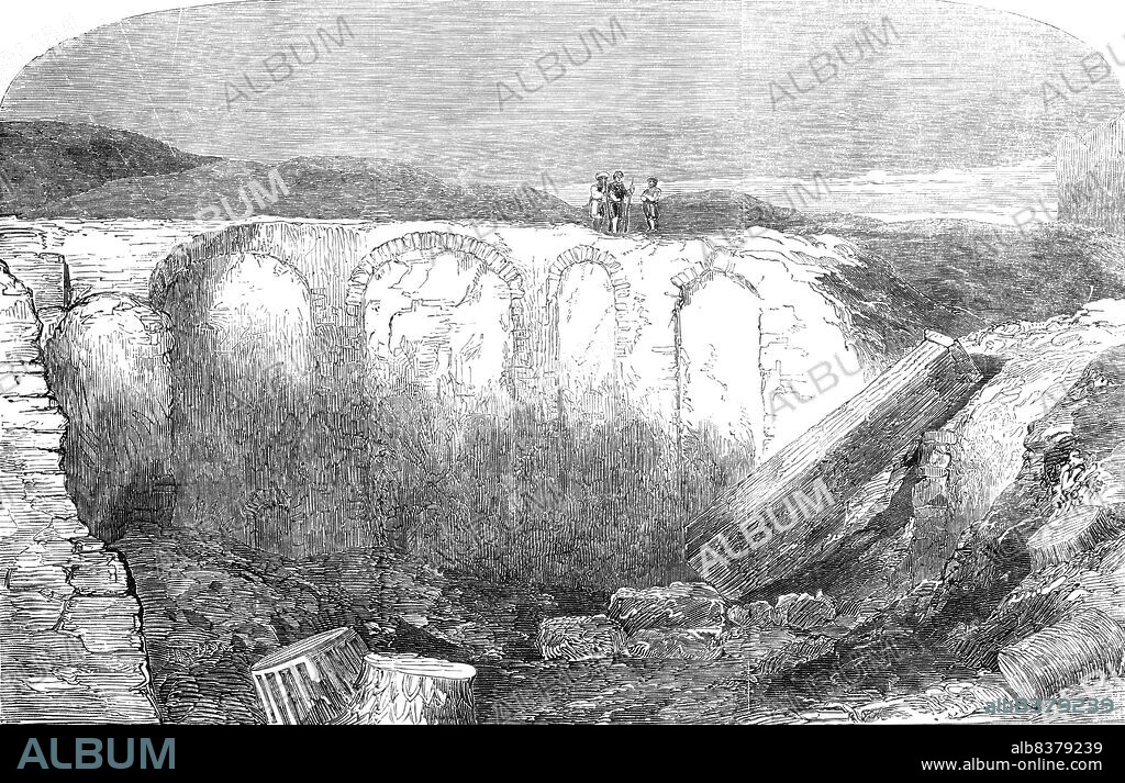 Recently-discovered remains of the Alexandrian Library, 1854. Archaeological remains in the city of Alexandria, Egypt. '...a few months since, the men employed digging foundations close to the British Consulate, came upon some very extensive ruins...Massive brick walls, numerous arches, portions of plastered ceilings, fragments of vitrified and charred matter - in some places bearing marks apparently made by close contact with the edges of ancient books, while in a state of semi-fusion; very fine monolithic columns of red granite; and large masses of stone - very like that now used in the construction of the Cairo and Alexandria Railway, and obtained at the quarries at Kaffre Douar, sixteen miles from Alexandria - are found in abundance in the ruins. Some very fine capitals of pillars and portions of columns of white marble are also amongst the discoveries'. From "Illustrated London News", 1854.