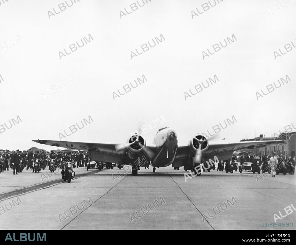 New York, New York:  July 14, 1938 Howard Hughes' Lockheed 14N Super Electra airplane at Floyd Bennett Airport in Brooklyn when he landed there after flying around the world setting a new record of 3 days, 19 hours and 14 minutes, breaking Wiley Posts's record. It was part of a promotion to attract people to the New York World's Fair.