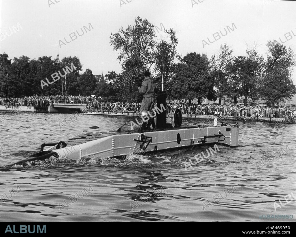 Orginaltext: Marinens dag, Spiggen. Anm: Den svenska miniubåten Spiggen. EX brittisk byggd 1954 Vickers-Armstrong, Barrow. 16,4m bredd 1,9m. Diesel-elektrisk, 7 - 9 knop. Besättning 5 man. Utrangerad 1972 Finns bevarad på Imperial War Museum, Duxford, GB. sites: STOCKHOLM ;SVERIGE.