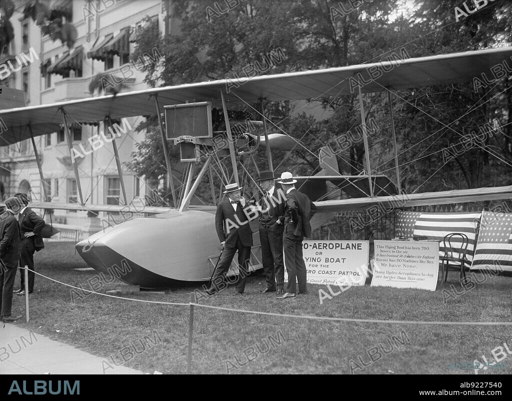 HARRIS & EWING. National Aero Coast Patrol Commission - Curtiss Hydroaeroplane or Flying Boat Exhibited Near House Office Building, Frankenfield; Rep. Curry; Bowman, 1917. Signs: 'Hydro-Aeroplane or Flying Boat for the National Aero Coast Patrol - National Aerial Coast Patrol Commission. This Flying Boat has been 700 hours in the Air. It has trained 50 Aviators for England. Russia has 80 Machines like this. We have None. Many Hydro-Aeroplanes to-day are larger than this one'.