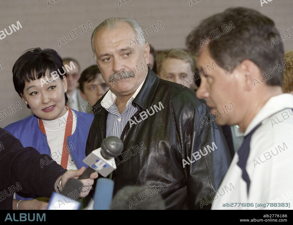 Alexandra Buratayeva, leader of Youth Unity association (left), film director Nikita Mikhalkov (center) and Russia's Emergency Situations Minister Sergei Shoigu (right) talk to journalists before football match between Unity party team and Russian Junior League select team.