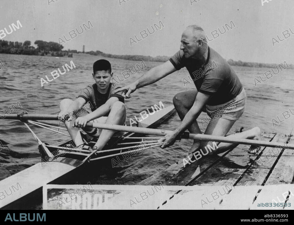 Bobby Pearce coaches his 14-year-old son, Jackie, winner of the Novice Singles at a recent Regatta in Canada. December 19, 1951.