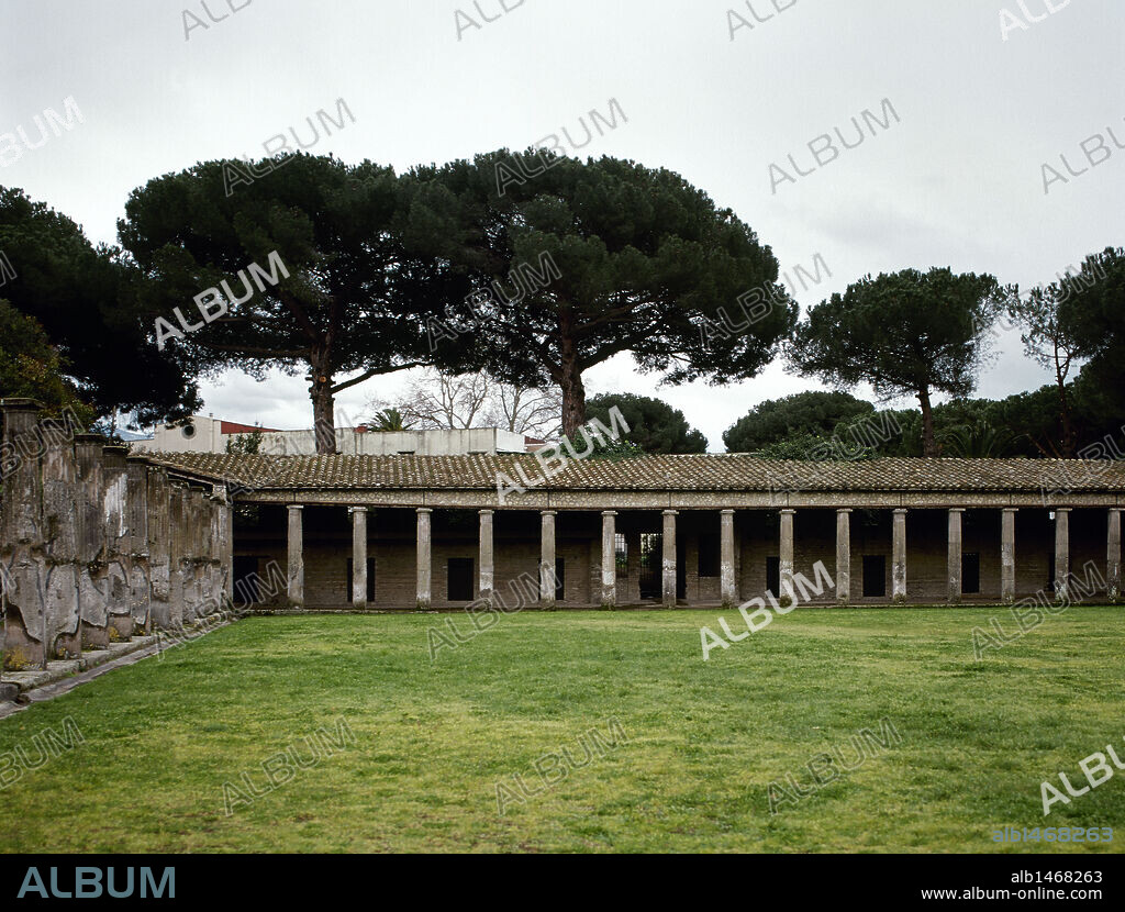 ARTE ROMANO. ITALIA. CUADRIPORTICO DE LOS GLADIADORES. Situado detrás de la gran escena del teatro, era en su origen la plaza porticada "porticus postcaenam" donde el público se reunía antes y durante los intervalos de los espectáculos. Durante el reinado de Nerón fue transformado en cuartel para gladiadores. Vista de la columnata. (Zona de los teatros). POMPEYA.