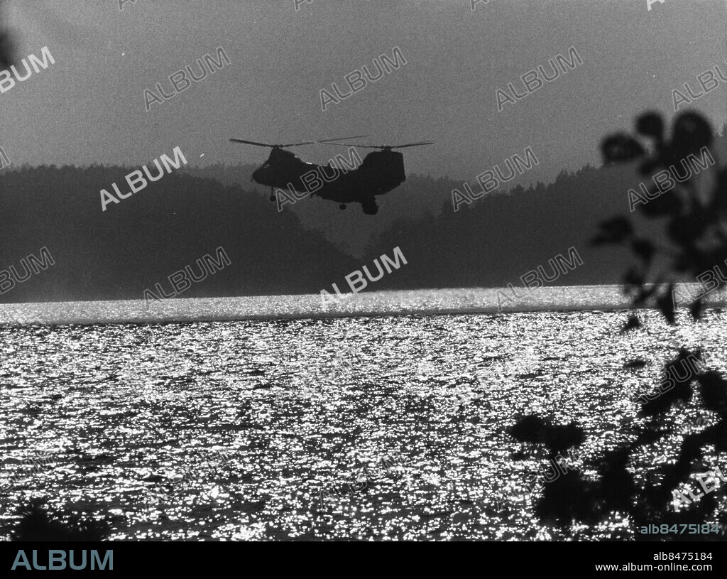 ARKIV 19821006. En av marinens hellikoptrar med hydrofonen i vattnet spanar efter en eller flera främmande Ubåtar som misstänks operera i Hårsfjärden nära Musköbasen i Stockholms skärgård 3 oktober 1982.. Foto: Jan Collsiöö / SCANPIX / Kod: 1001.