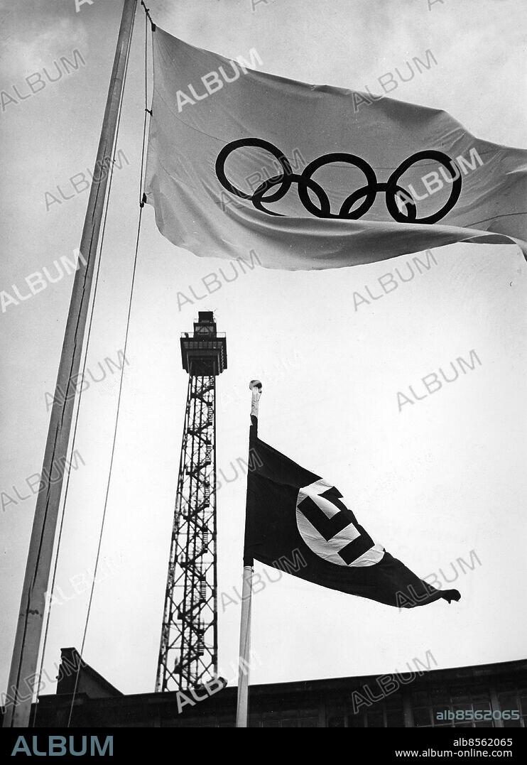 TYSKLAND BERLIN 1936-07-16.. En olympisk flagga och en nazistflagga fladdrar på sina stänger inför de olympiska sommarspelen i Berlin 1936.. Foto: Scherl Bilderdienst / AB Text & Bilder / SVT / Kod: 5600. Tysk originalbildtext.. Mapp: Olympiareportage Åskådare I 263 r1. Hakkors Olympiska ringar.
