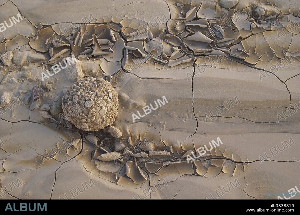 Armored mudball in Badlands National Park, South Dakota.  Armored mudballs are formed when water washes down a stream bed or slope, rolling clay into round balls that collect pebbles and sand.