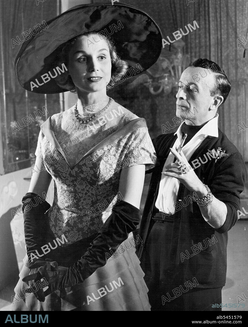 Spotlight On Skirt (First of Seven) -- Preparing one of his spring model ***** showing, Rome stylist Emilio Schubert ***** final check-over on an Indigo Blue-Organdy afternoon Gown. Diagonal pleats cover the entire skirt and chantilly lace decorates the bodice. Neck line is ideal for jewelry, which Schubert dearly loves, as witness the armful of gold bracelets and diamonds he always wears.Though he is Italy's acknowledged leader of fashion, the artist with the bangles, the rings and long, pointed nails was born in Germany. January 25, 1952. (Photo by United Press - ACME).