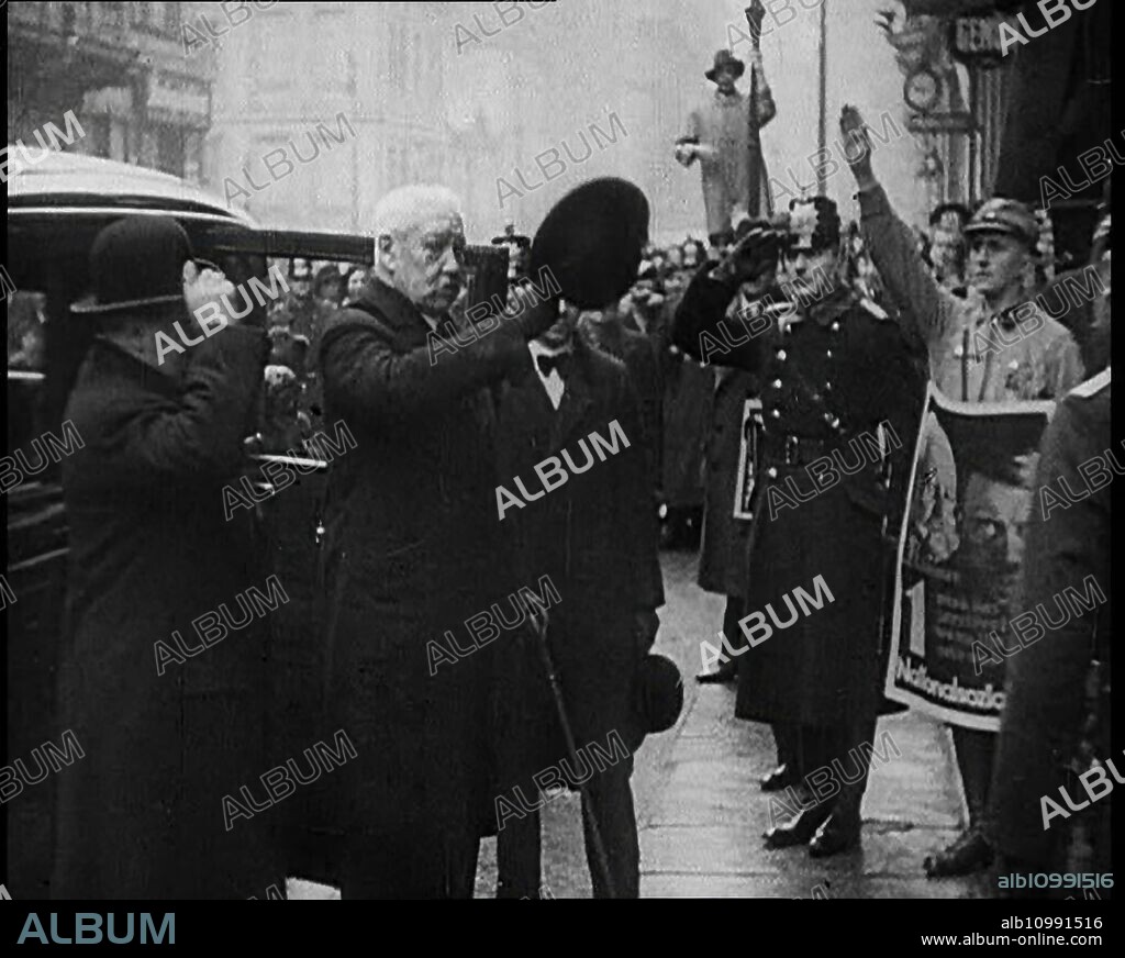German President Paul von Hindenburg Greeting a Crowd, 1933. 'Suspicious though he was of the [National Socialist] Party, the aged president Hindenburg chose to support it as the least of many evils'. Note poster of Hindenburg and his chancellor Adolf Hitler at right. From "Time To Remember -  The Time Of The Monster", 1933  (Reel 2); documentary film about events of 1933, rise of Roosevelt and Hitler.