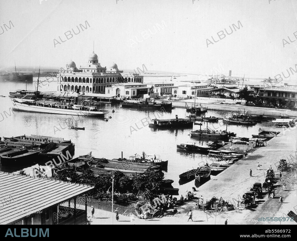 Port Saïd (Ägypten), Verwaltungsgebäude der Suezkanal-Gesellschaft. Blick vom Postamt über den Handelshafen auf das Verwaltungsgebäude und die Einfahrt zum Suezkanal. Photographie, anonym, um 1880. Paris, Collection Bernard Garrett.