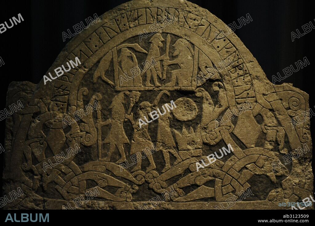 Piedra grabada con la representación de los dioses Odin, Thor y Frey en la parte inferior. En la parte superior se muestra un sacrificio a Odin. Un hombre en pie entrega una lanza a una figura sentada. Procedente de Sanda, Isla de Gotland. Utilizada como parte de un ataúd. Detalle. Museo Histórico. Estocolmo. Suecia.