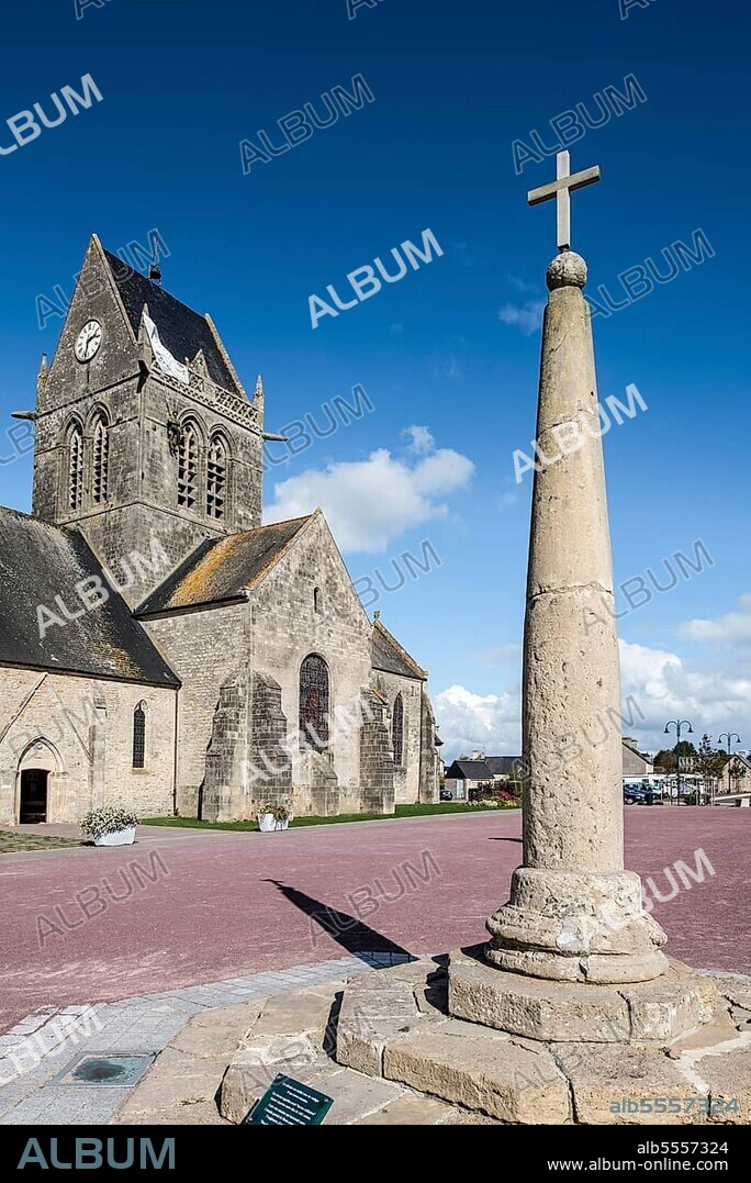 Milliarium, stone along Roman streets and Sainte-Mère-Église church with parachute memorial in honour of paratrooper John Steele, who was trapped on the church tower during D-Day, Normandy, France