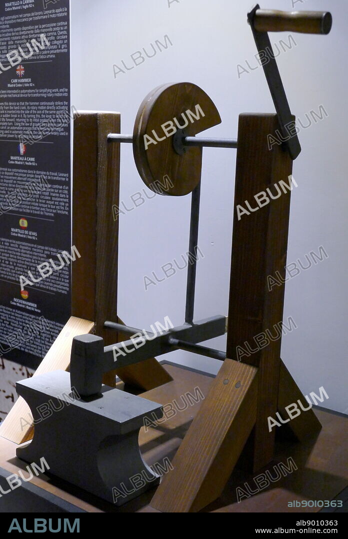 Re-construction of a Cam Hammer, from a drawing by Leonardo da Vinci, in the Madrid Codex I, folio 92 v. Leonardo applied a cam to this simple mechanical device for transforming rotary motion into intermittent motion. The energy that moves this device so that the hammer continuously strikes the anvil is derived directly from the hand crank, its rotary motion directly activating the cam: the hand crank is inserted into the side of the axis of the same and has a circular profile with a sudden break in it. By turning this, the lever to which the hammer is attached tilts forward, returning to its initial position when the hand crank has done a complete turn. Using the law of gravity, the hammer continues to fall heavily on the anvil; an automation process that relieves human fatigue. After having been long used in automatic meshes, the cam is now widely used in car engines, which deliver power by activating a camshaft.. Leonardo da Vinci (1452-1519), Italian artist and polymath.