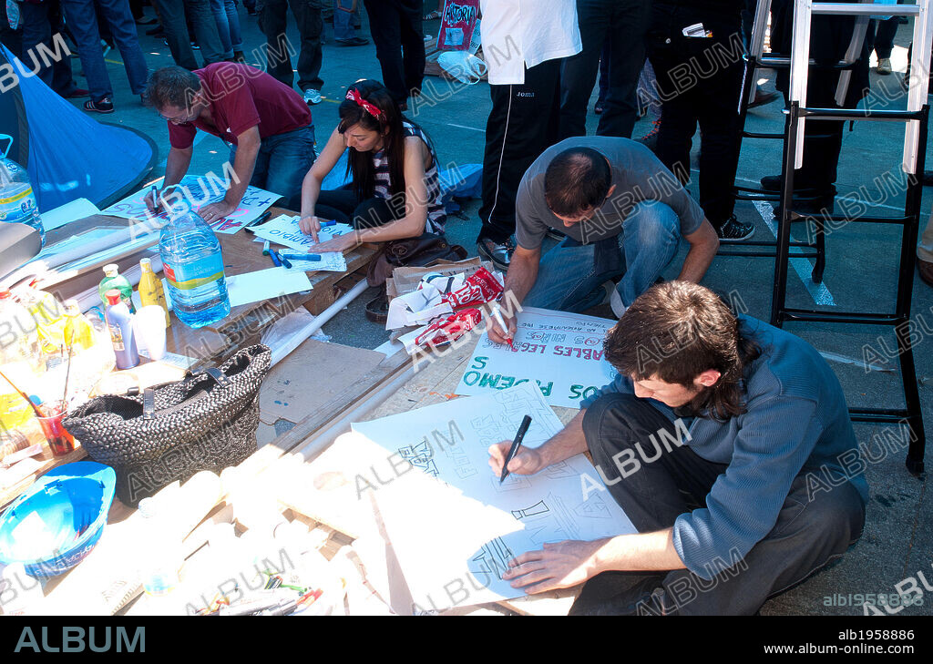 MOVIMIENTO 15-M o MOVIMIENTO DE LOS INDIGNADOS. Movimiento ciudadano que salió de forma pacifica a la calle para promover una democracia más participativa. Acampada de protesta del movimiento 15 de mayo en la Puerta del Sol. Manifestantes realizando pancartas. Madrid. 2011. España.